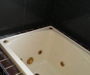 Bathtub with dark tiling installed newcastle